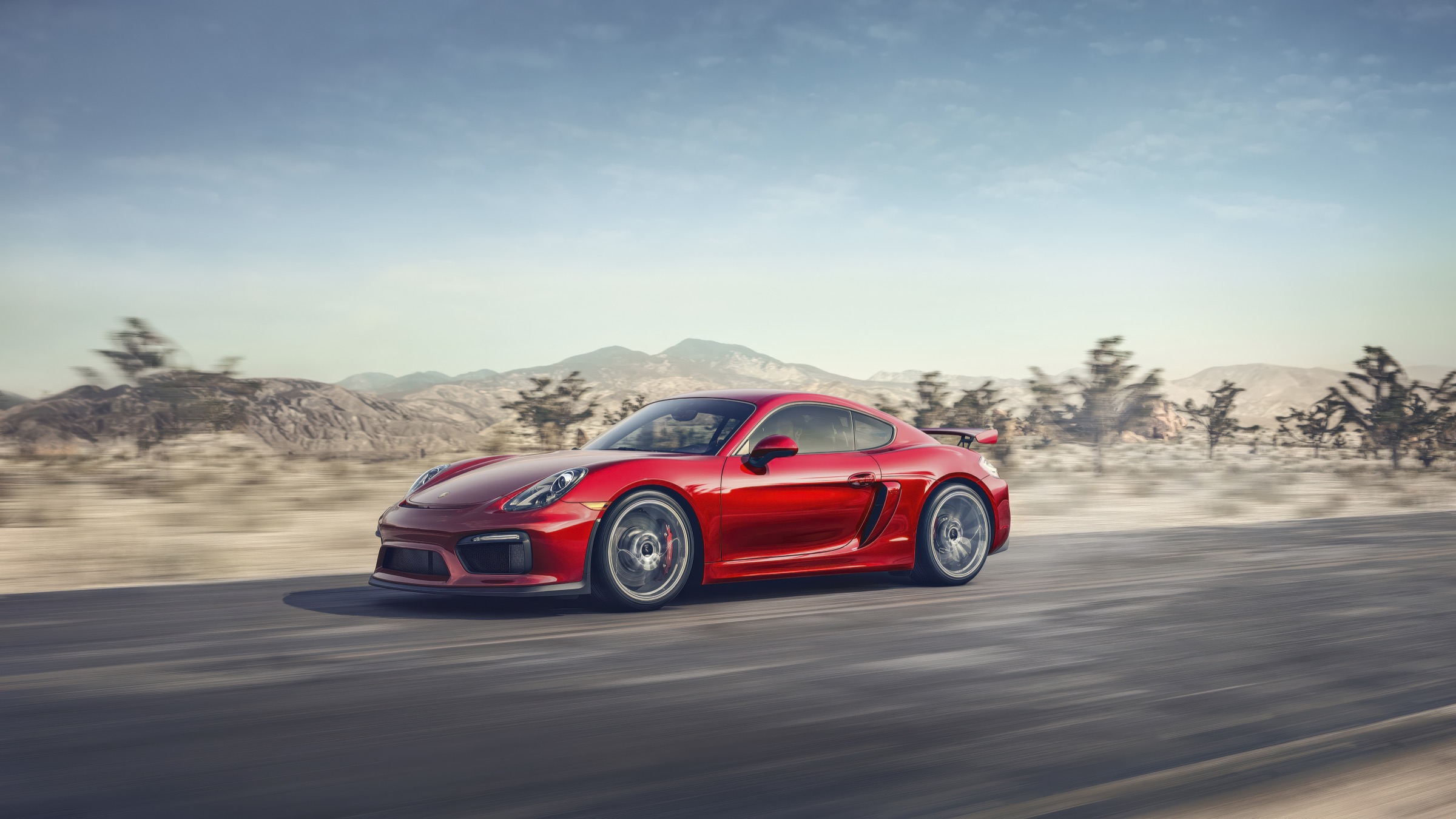 Red Porsche driving through the Joshua Tree desert